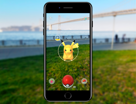 A Pikachu is on a mobile phone screen playing Pokémon Go