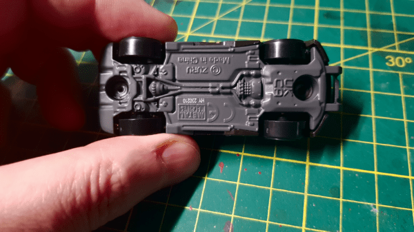 A closeup of the underneath of a Metal Machines brand car, showing the plastic rivets you can cut out with a craft knife before painting it for Gaslands
