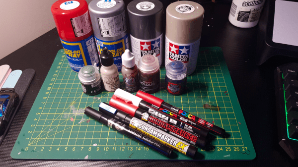A photo of several kinds of spray paint, brush paints and paint pens for painting Gaslands Cars